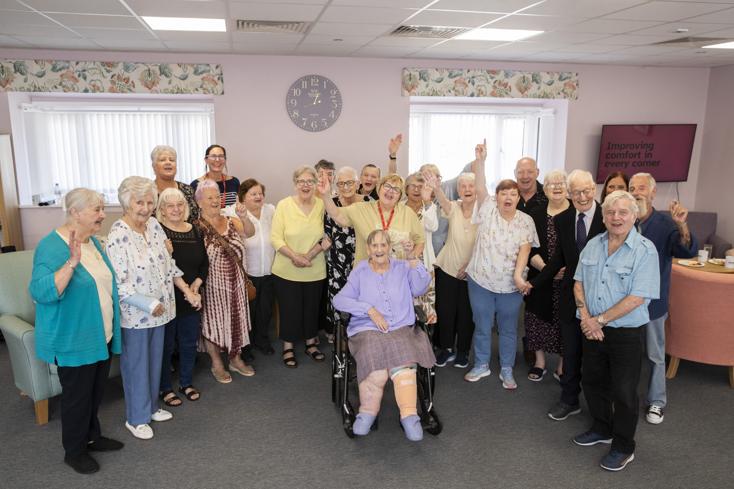 A picture of a group of Thirteen Housing residents who live at Glastonbury house, celebrating works completing on site